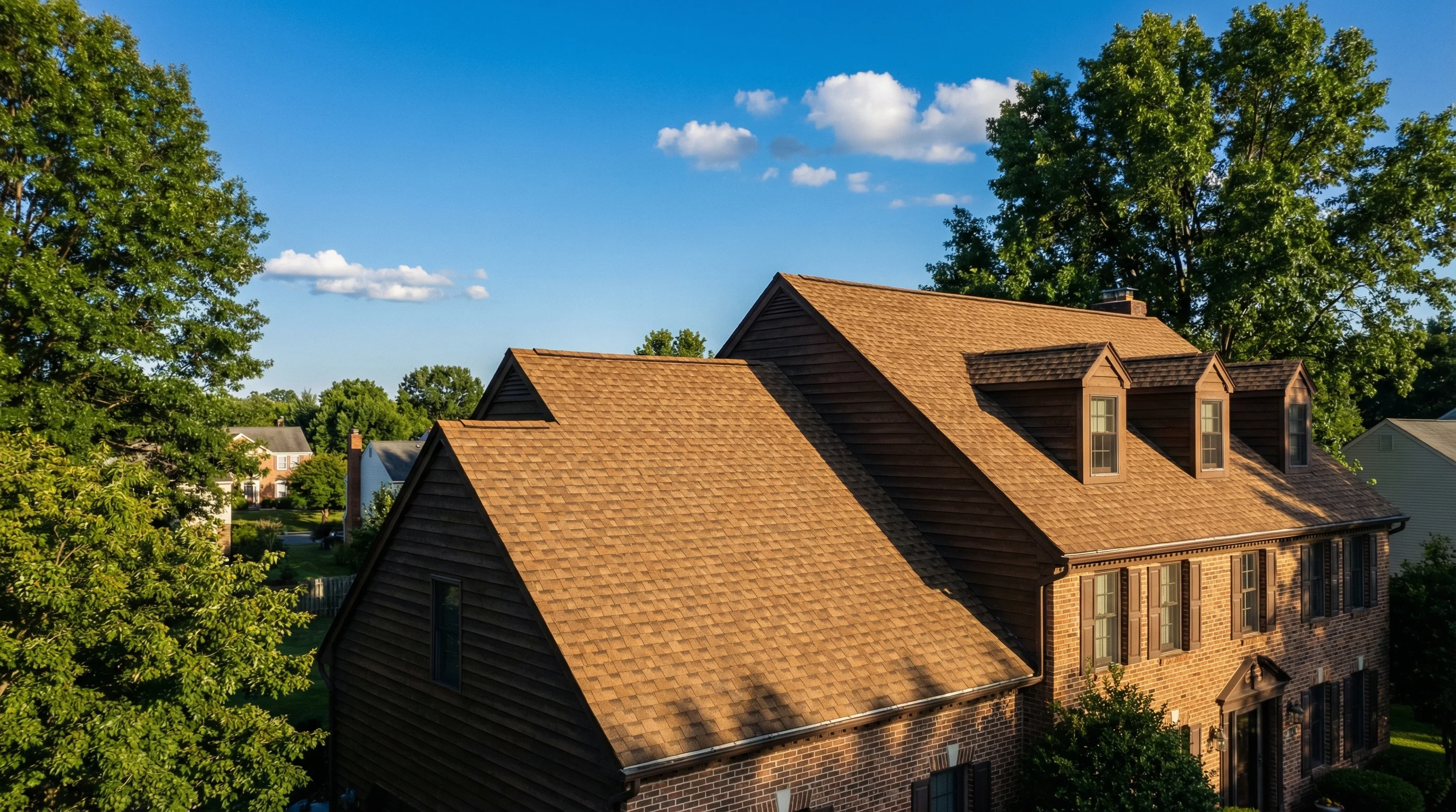 Colonial home with a clean asphalt shingle roof under blue summer sky in suburban Philadelphia